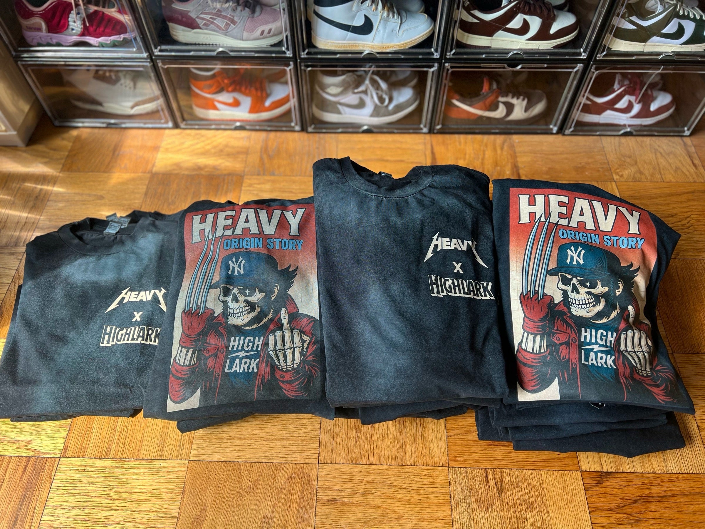 HEAVY x Highlark Wolverine Origin Story tees folded, showing front chest logo and full-back comic-style print.