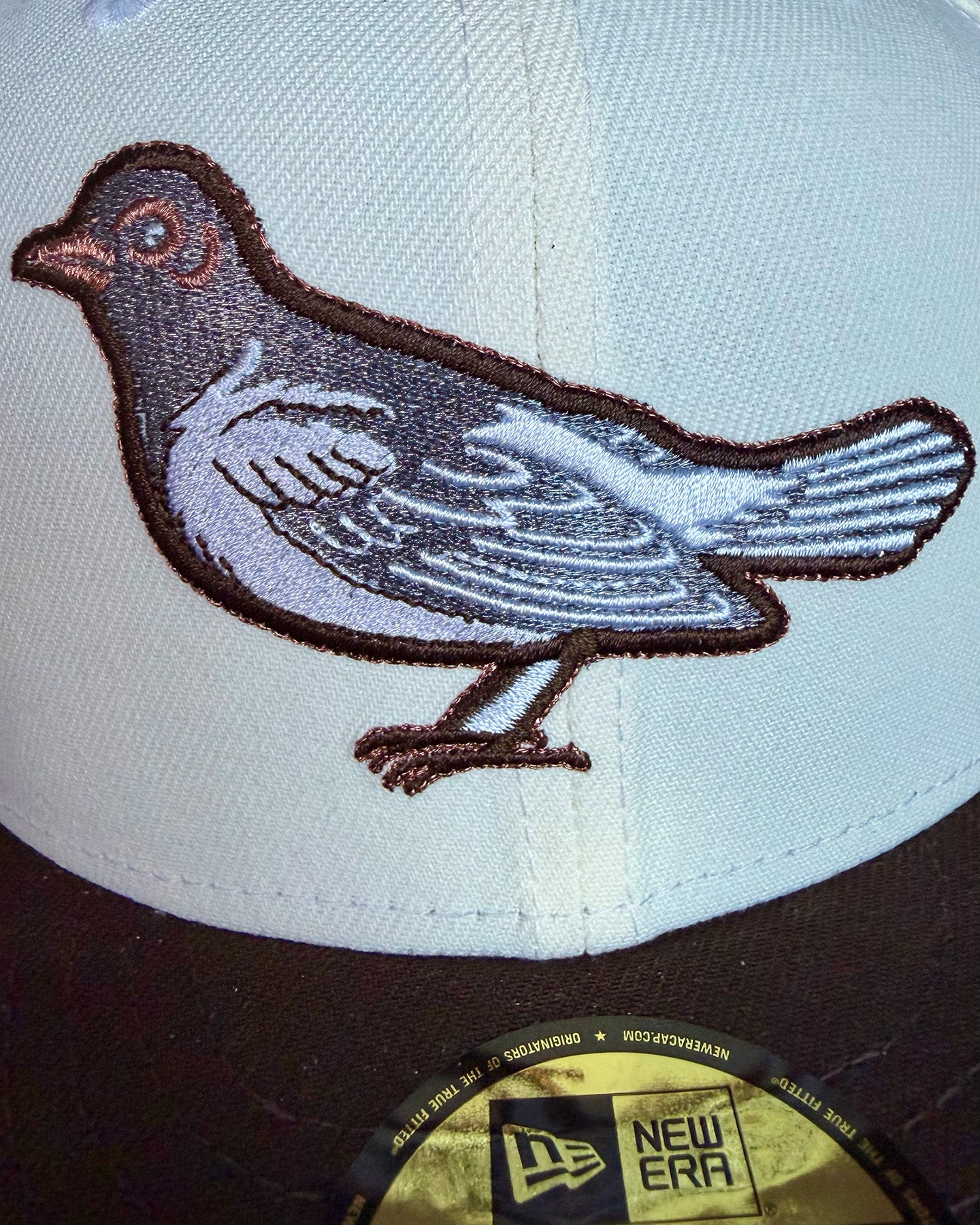 Close-up of vintage Orioles bird embroidery on Highlark Orioles 1.0 fitted hat showing copper detail