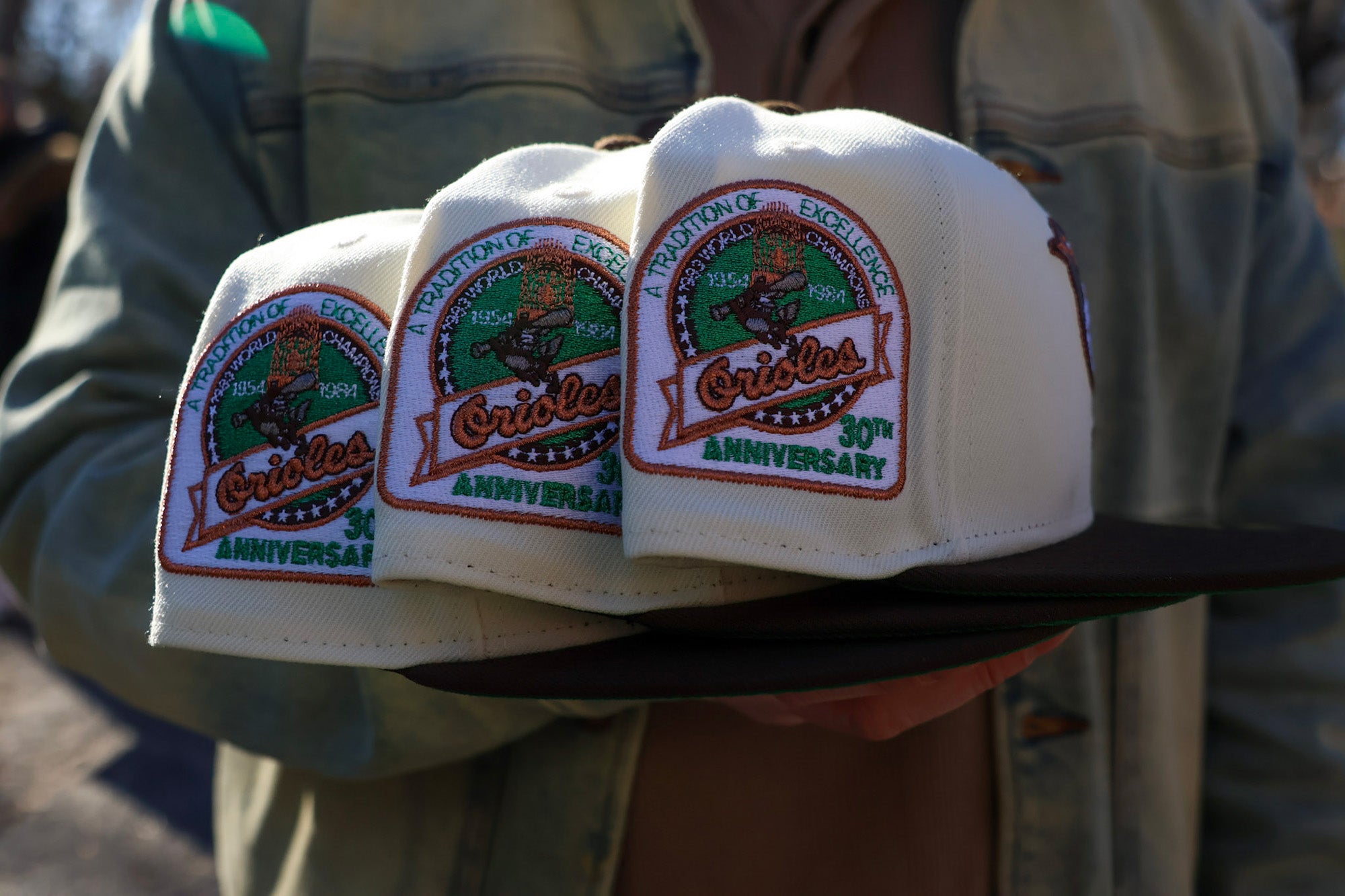 Tight grouping of Highlark Orioles 1.0 fitted hats showing 30th Anniversary patches