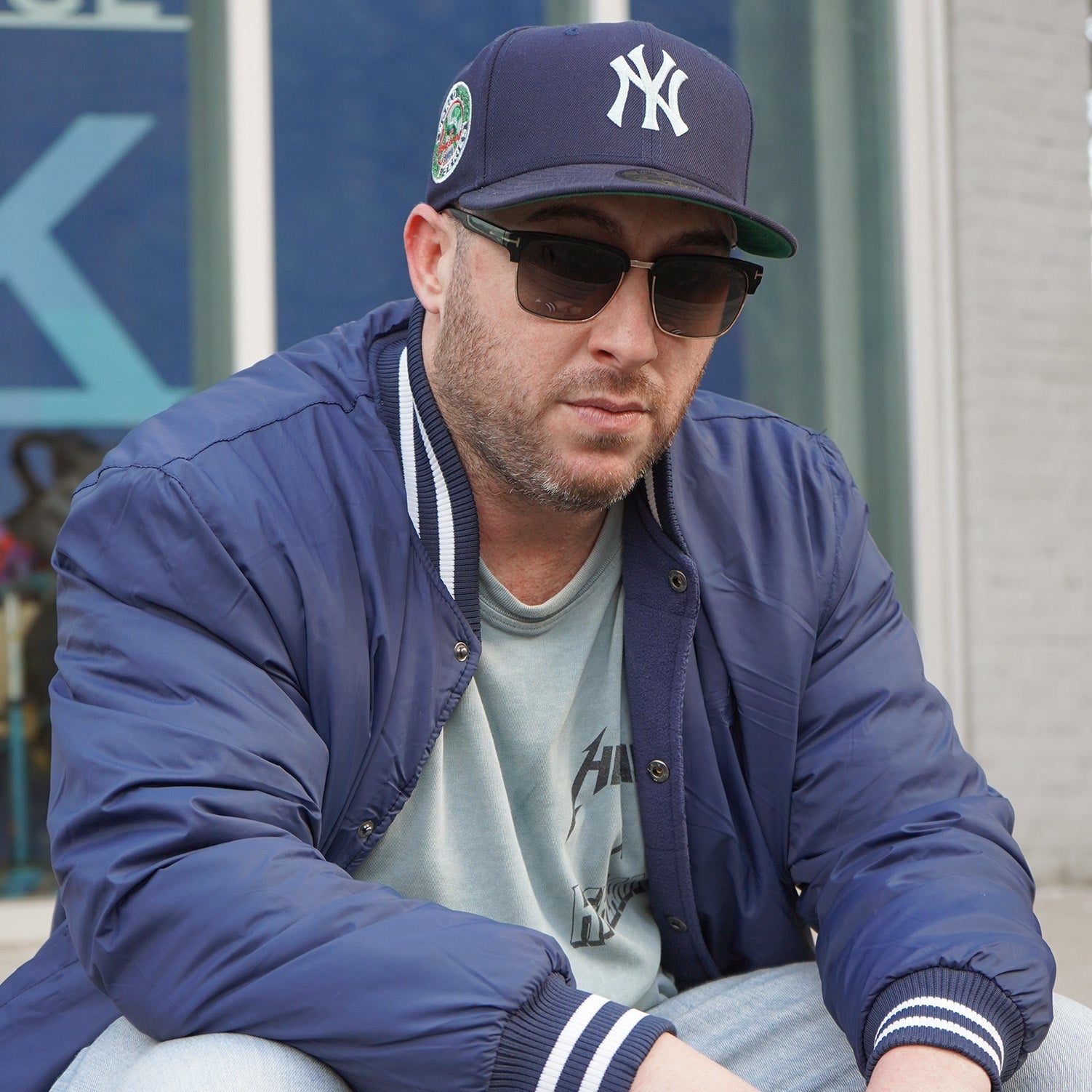 Mitch Highlark wearing the Timeless Yankees fitted hat outside Highlark storefront, top-cropped to feature full head and hat