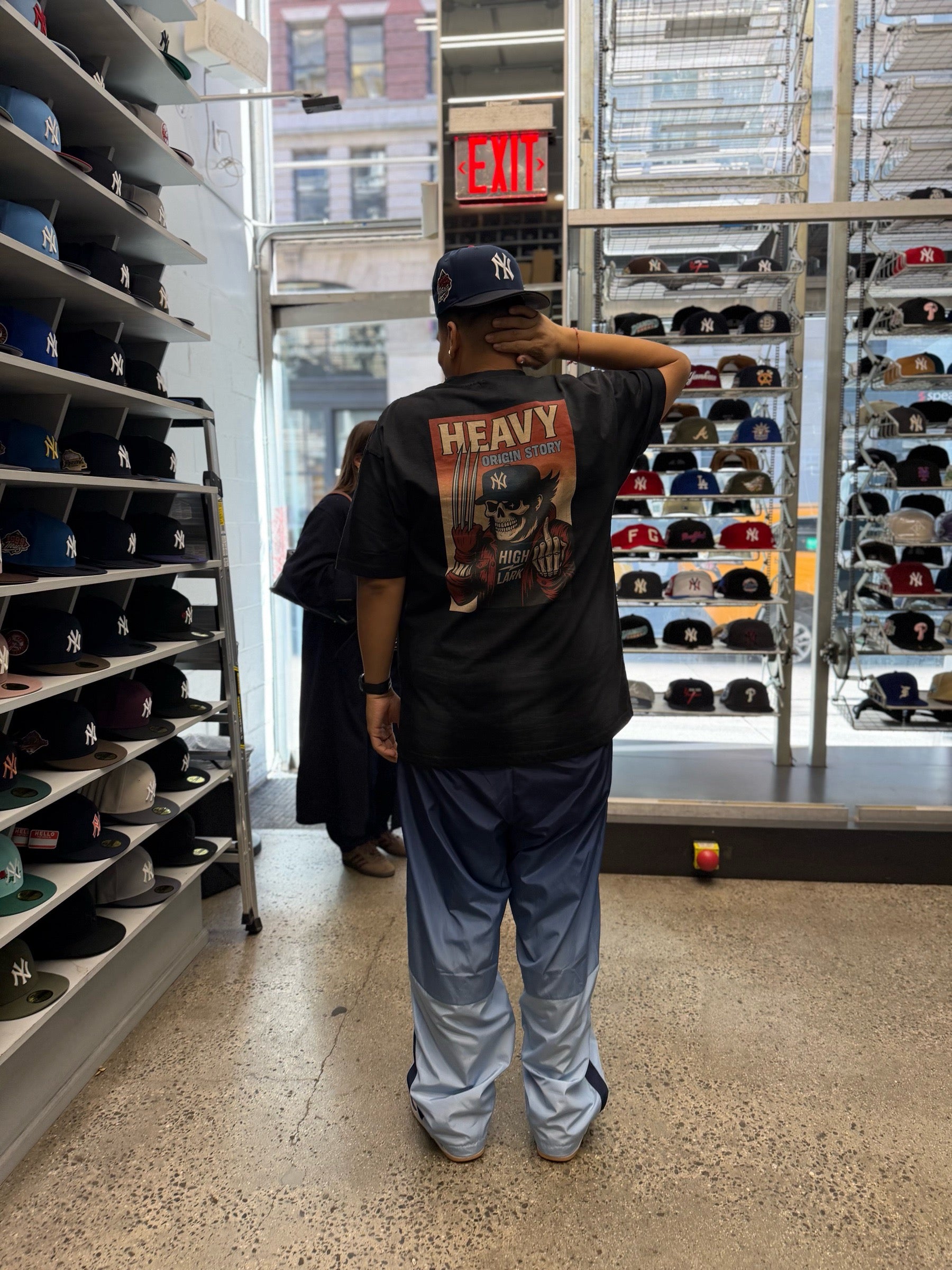 HEAVY x Highlark Wolverine tee on model, back graphic angled view, retail interior at Home Game NYC.