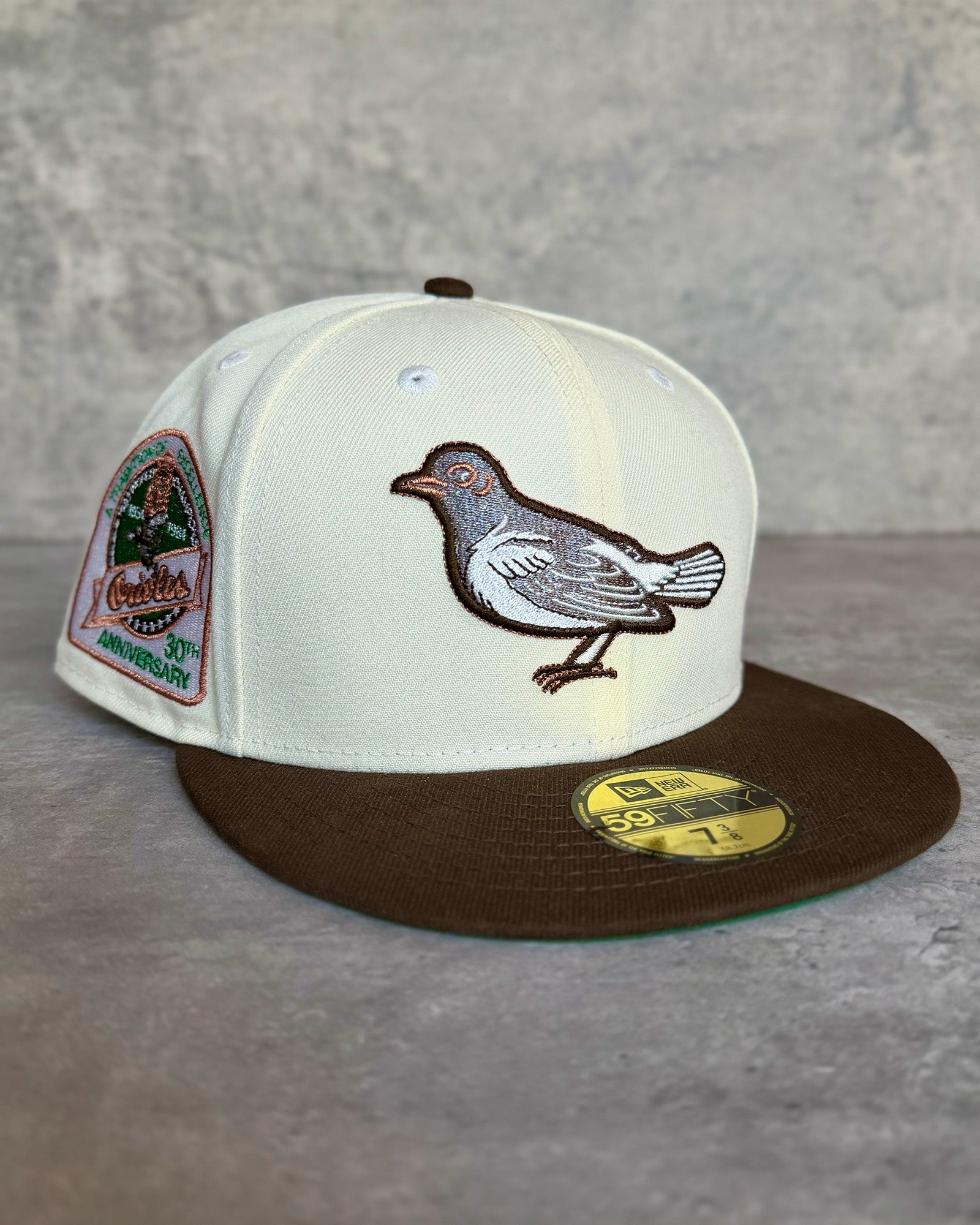 Highlark Baltimore Orioles 1.0 fitted hat with off-white crown, walnut visor, and vintage Orioles bird embroidery in copper