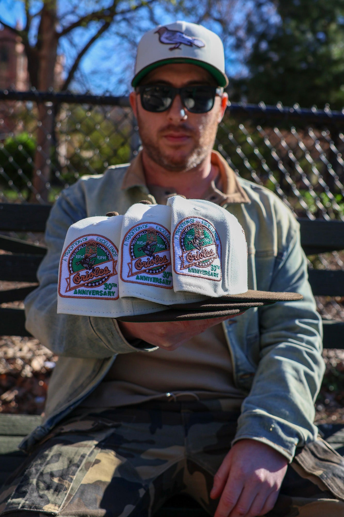 Multiple Highlark Orioles 1.0 fitted hats arranged in a fan showing patch detail