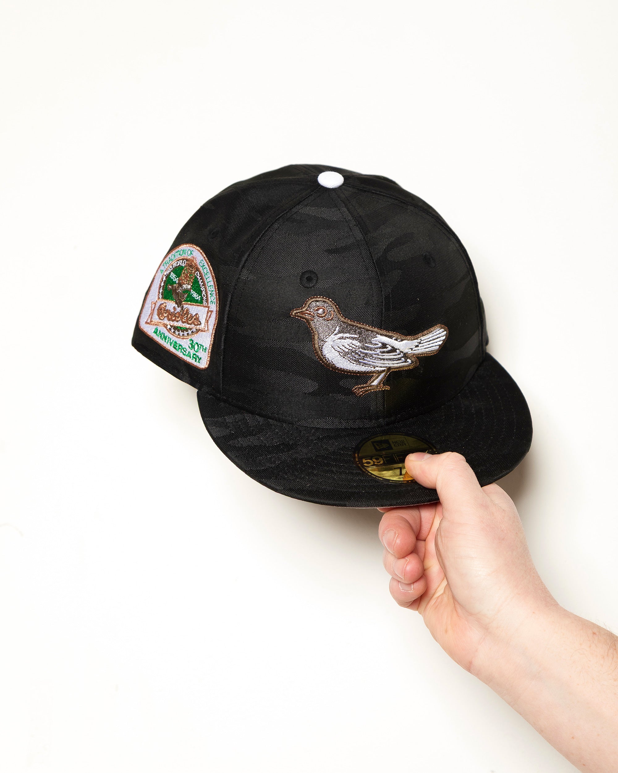 Highlark Baltimore Orioles 3.0 fitted cap front view, tonal black camo crown with blacked out batterman and 30th Anniversary sidepatch