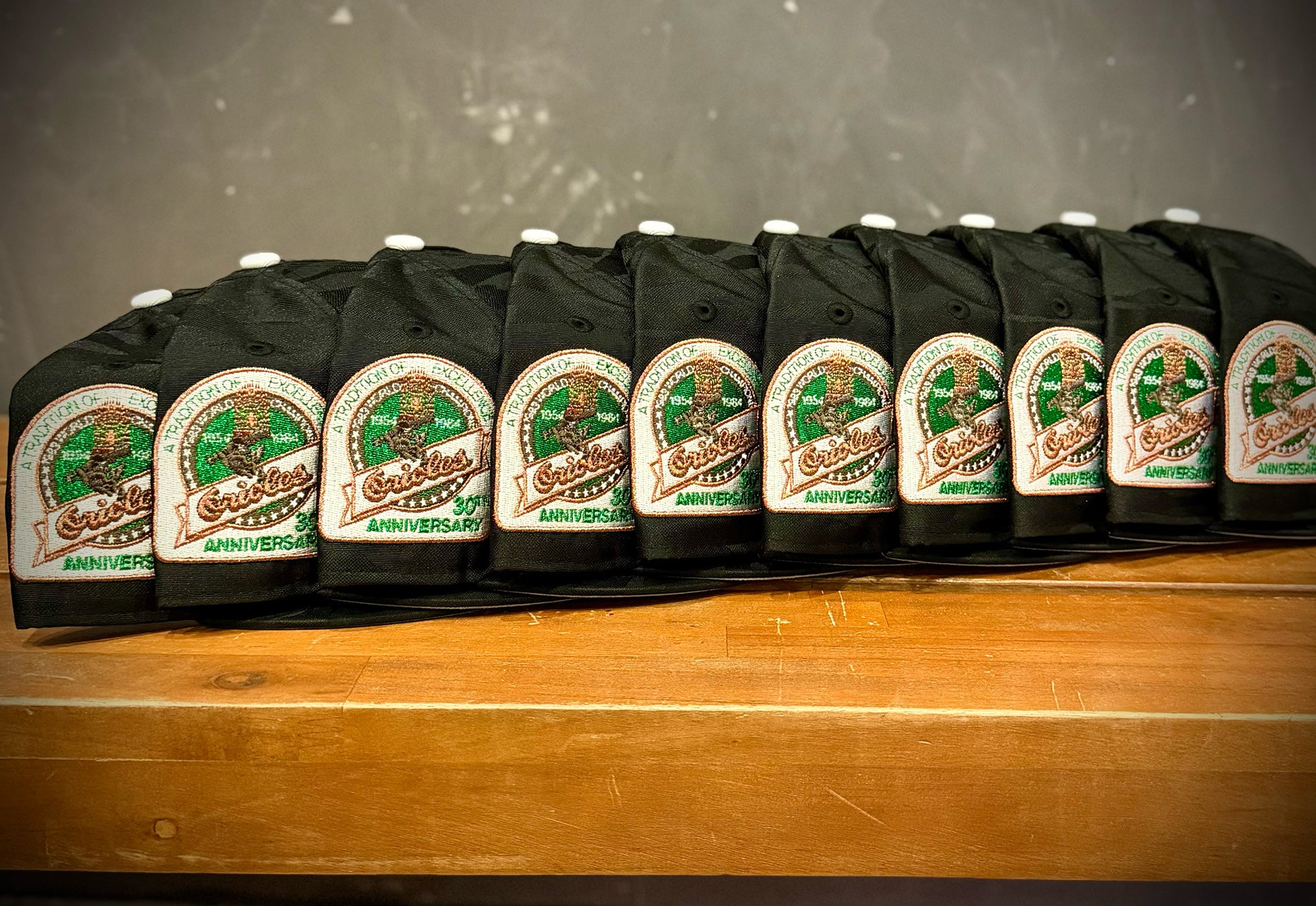 Highlark Baltimore Orioles 3.0 sidepatch lineup, row of hats showing 30th Anniversary A Tradition of Excellence patch in metallic copper and green