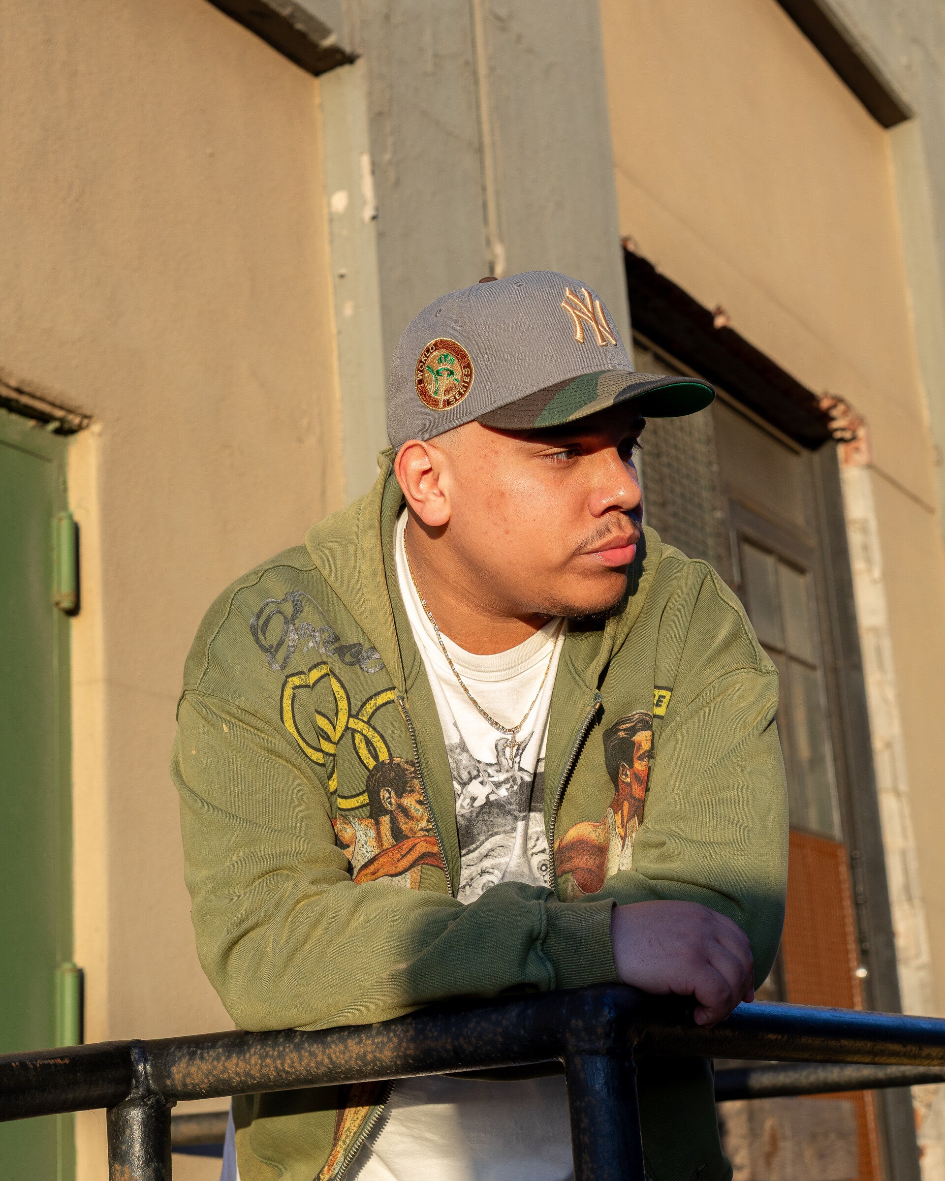 Curated stream: friend in golden-hour profile, cream Yankees fitted, olive bomber